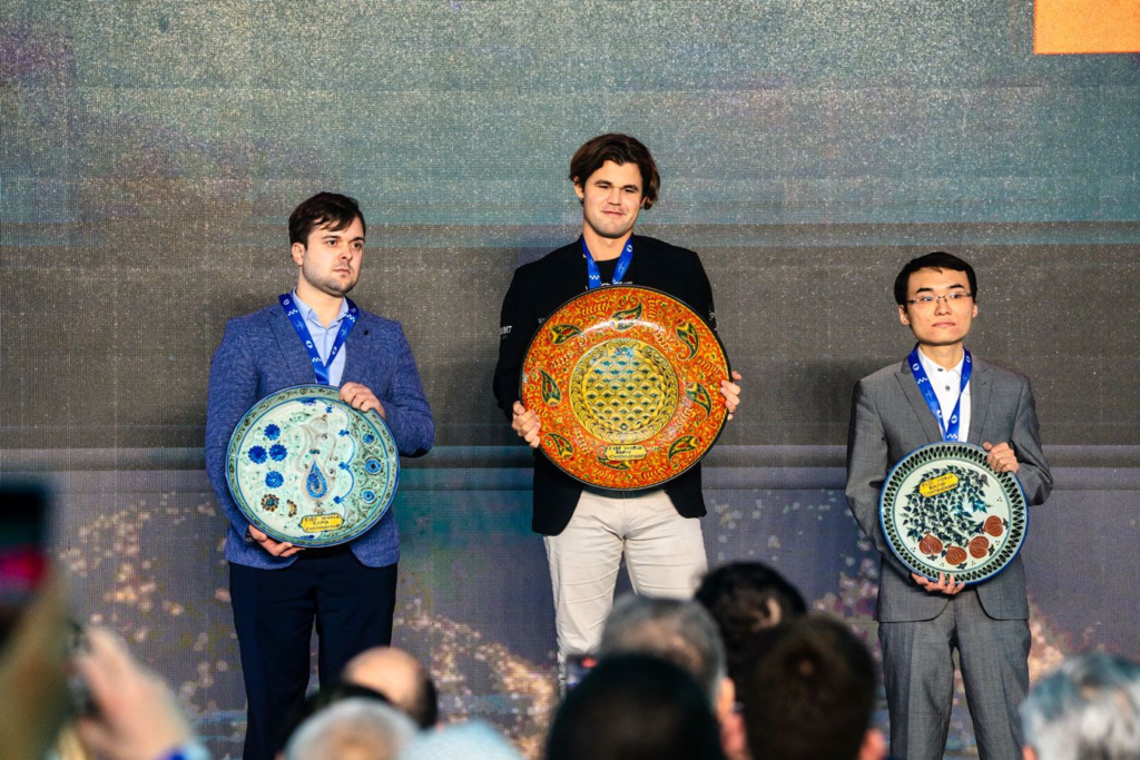 Magnus Carlsen during the closing ceremony of the World Rapid Championship with Vladimir Fedoseev and Yu Yangyi. Photo: Maria Emelianova/Chess.com.