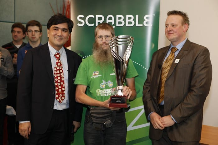 Scrabble Champions Tournament director John Chew (left), posing in Prague with Nigel Richards (center), who’d just been crowned as world Scrabble champion for 2013 (a feat he’d repeat in 2018 and 2019). Richards is widely regarded as history’s greatest tournament-Scrabble player.