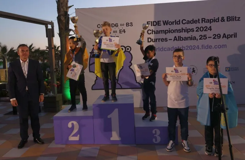 Oleksii Nakonechnyi stands on the first-place podium after winning the FIDE U10 World Cadet Rapid Chess Championship in Durres, Albania, held April 25-29, 2024. (International Chess Federation)